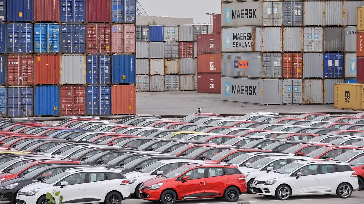 Rows of export vehicles beside shipping containers at the Port of Koper